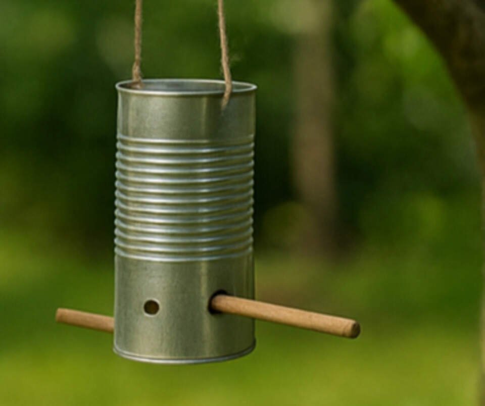A DIY tin can bird feeder with perches.