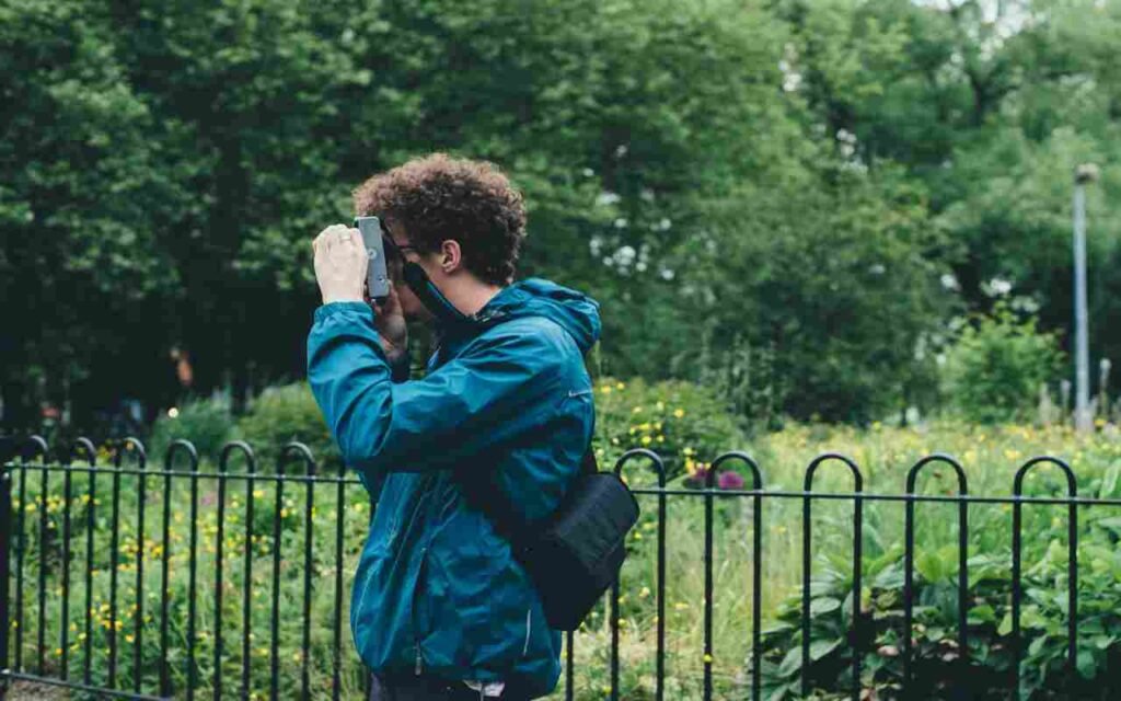 A person taking photos of birds in the garden.